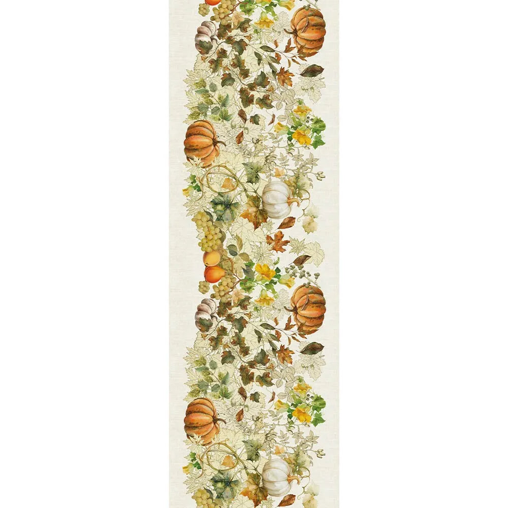 A detailed repeating textile pattern on a cream cotton-linen table runner, featuring illustrated harvest pumpkins, clusters of green grapes, and vibrant autumn foliage in orange, gold, and green tones.