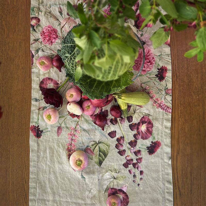 Floral patterned table runner with a potted plant on a wooden surface