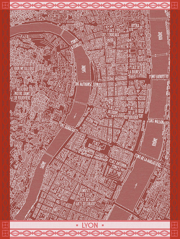 A map-style print of Lyon, France, on a cotton dishtowel in a muted dusty rose and white color scheme with a decorative red border and the word "LYON" at the bottom.