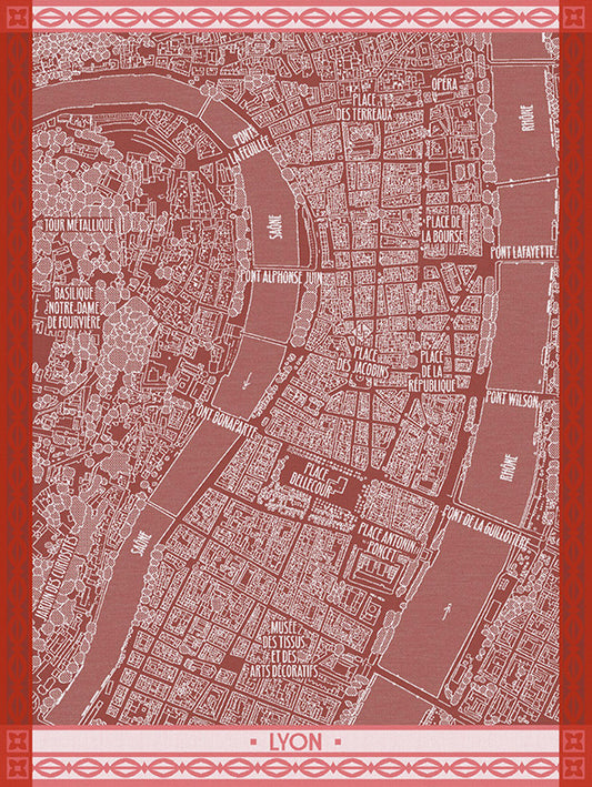 A map-style print of Lyon, France, on a cotton dishtowel in a muted dusty rose and white color scheme with a decorative red border and the word "LYON" at the bottom.