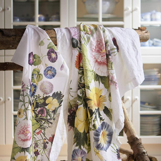 Floral-patterned linens hanging on a wooden rack in a kitchen.