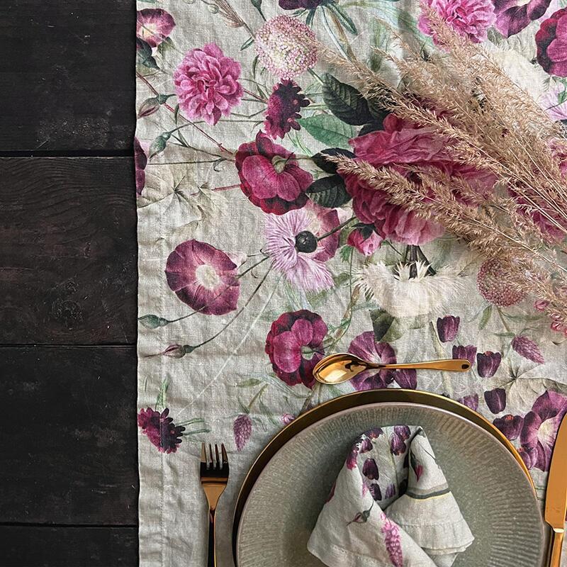 Green Blossom Garden table runner with pink and purple flowers on a wooden table.