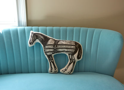 Custom horse-shaped decorative throw pillow featuring a vintage hand-sketched illustration of a horse in a striped blanket sitting on a blue couch.