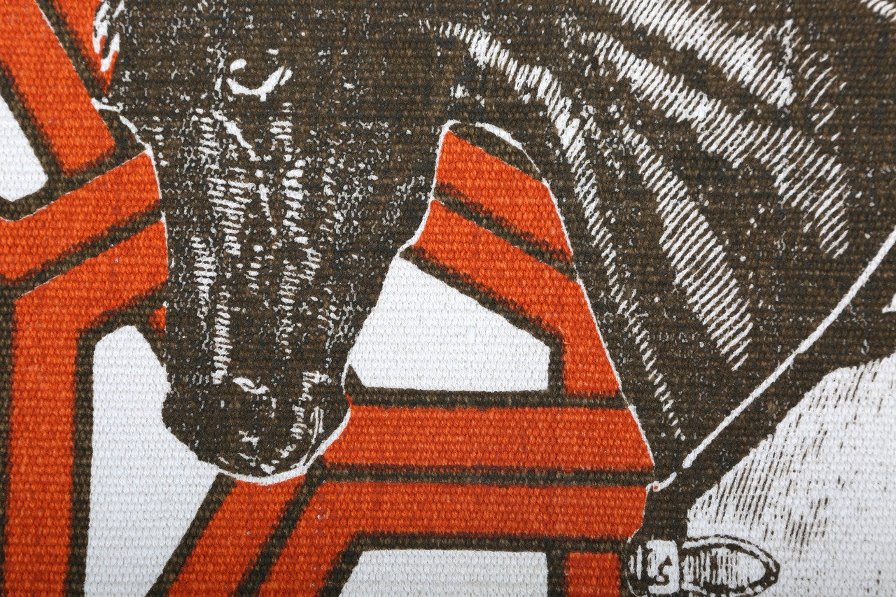 Detail of cotton, screenprinted fabric rug with a thoroughbred horse illustration and geometric pattern.