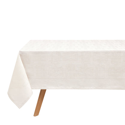 A light grey Hôtel Particulier Jacquard tablecloth draped over a table, featuring a repeating geometric interlocking-link pattern.