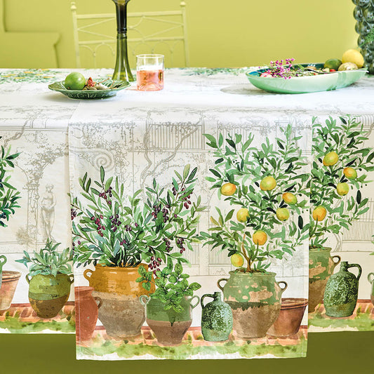 The Jardin Provencal Olive Table Runner featuring printed lemons and potted plants  in green hues on a clean white base.
