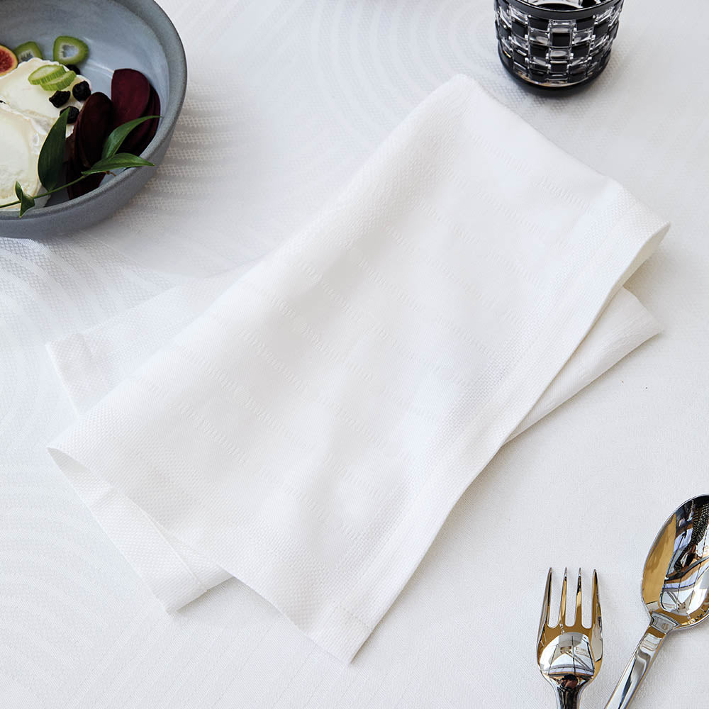 Le Cercle Blanc Jacquard napkin on a set table. 