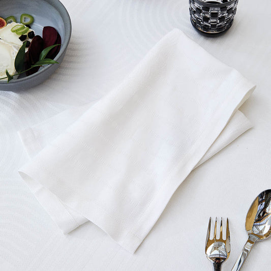 Le Cercle Blanc Jacquard napkin on a set table. 