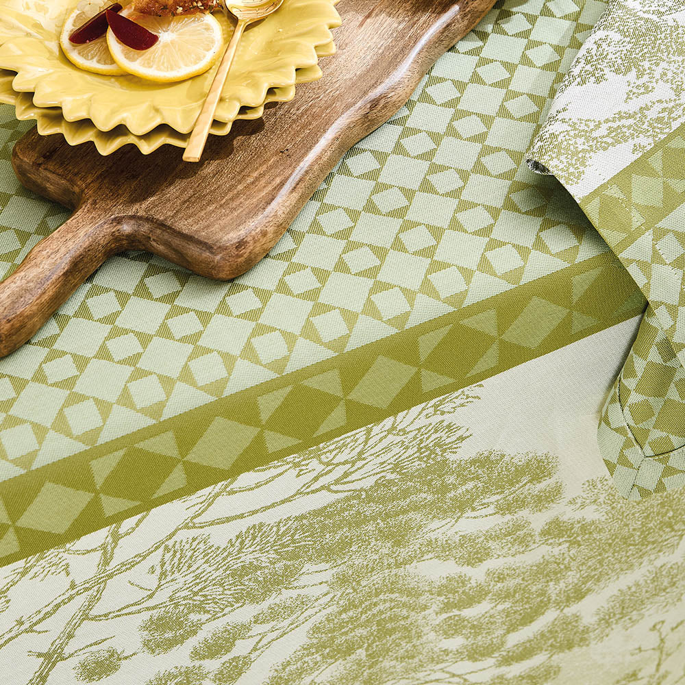 Close-up of Le Sud Vert Jacquard Tablecloth in lush green cotton featuring an intricate tree outline and geometric patterns