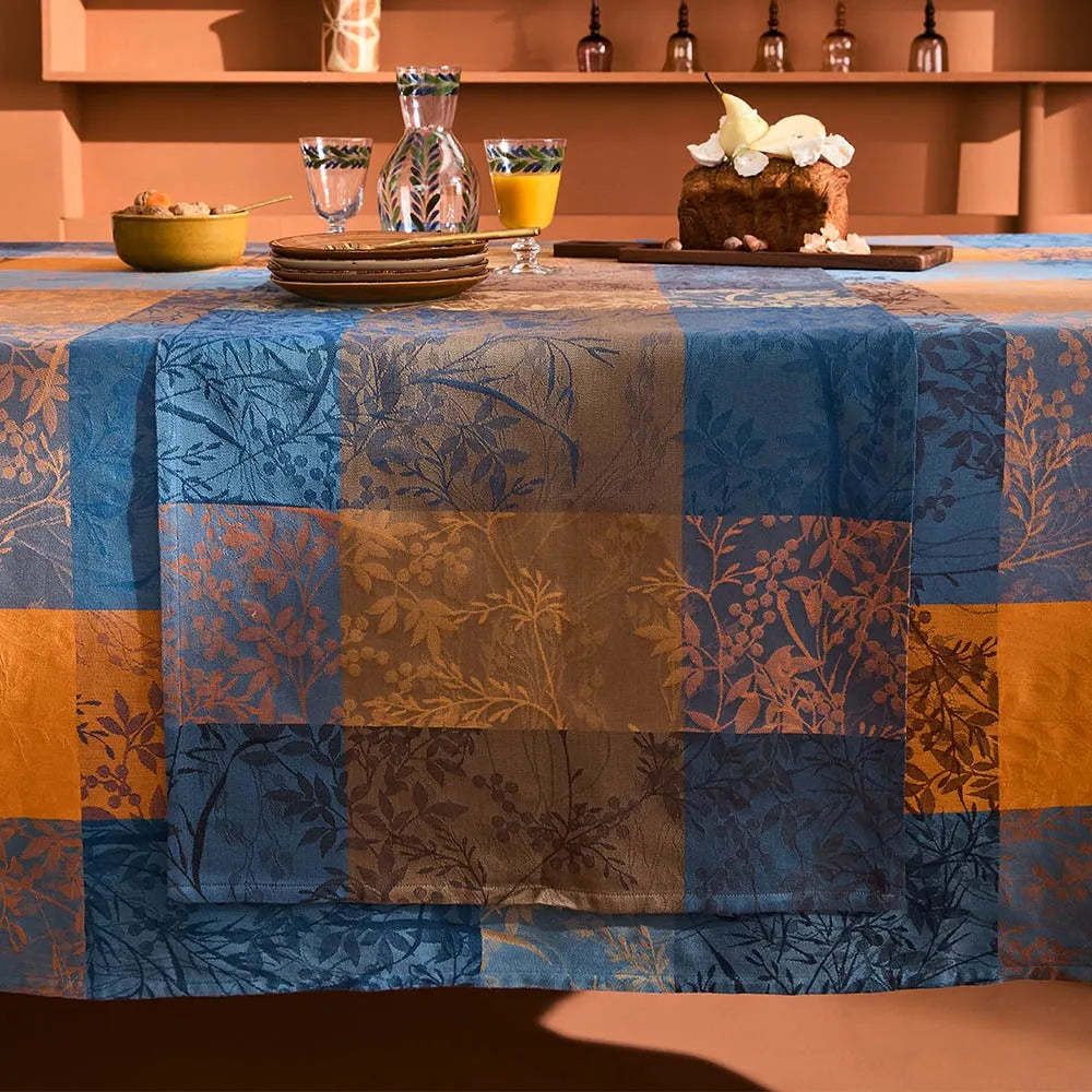 Tablecloth with a patchwork design in blue, orange, and brown on a dining table.
