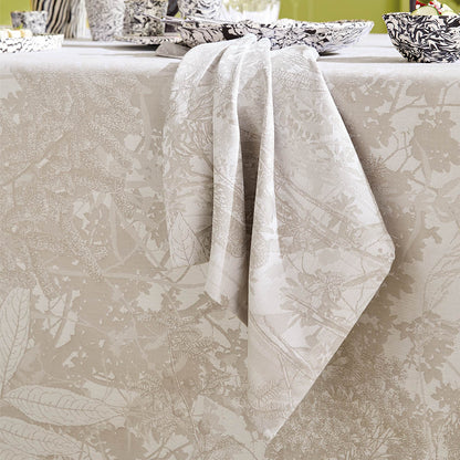 Mille Esprit Jardins Napkin in a cream botanical floral cotton jacquard draped elegantly across a matching tablecloth. 