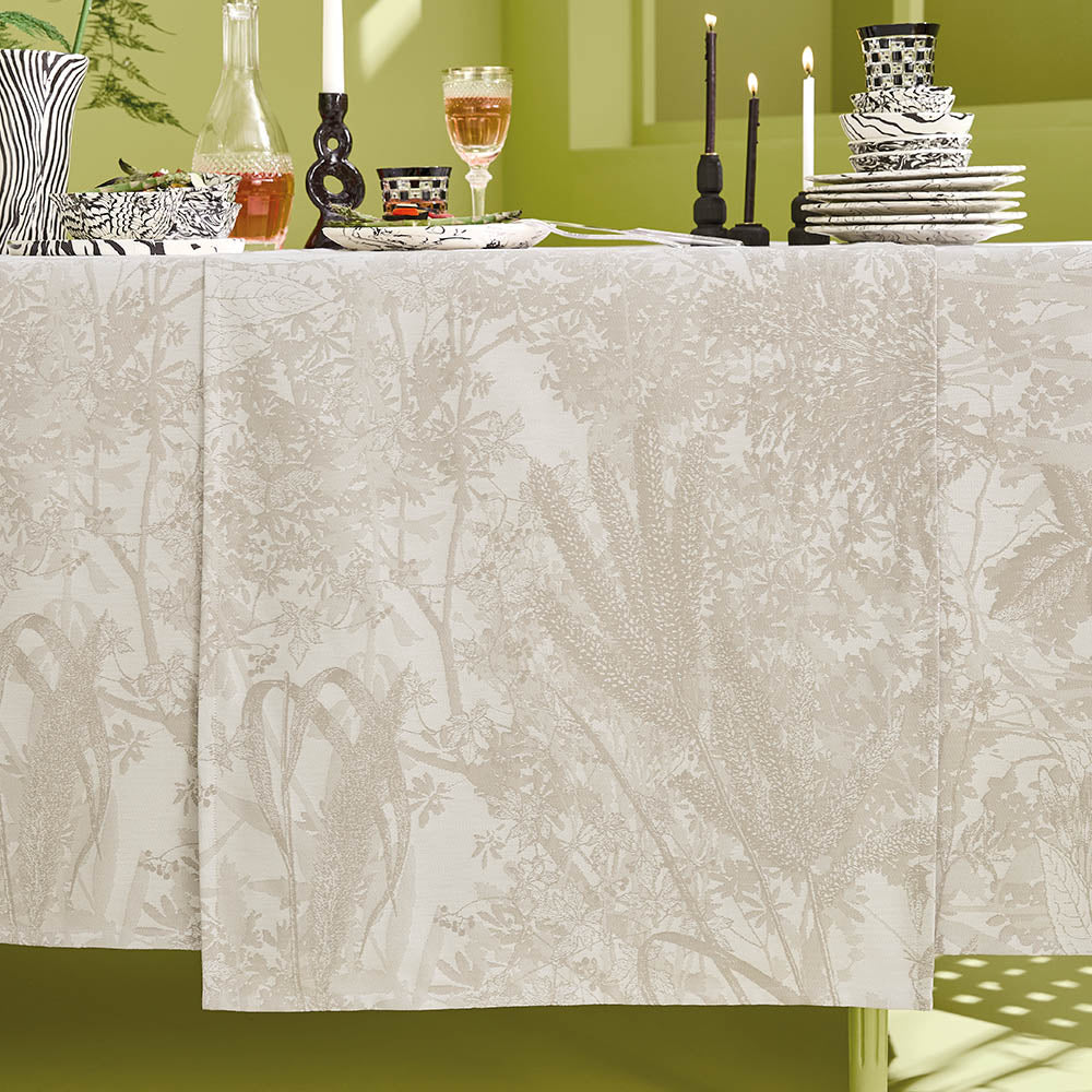 Mille Esprit Jardins Table Runner in a cream botanical floral cotton jacquard draped elegantly across a set table in a lime green room. 