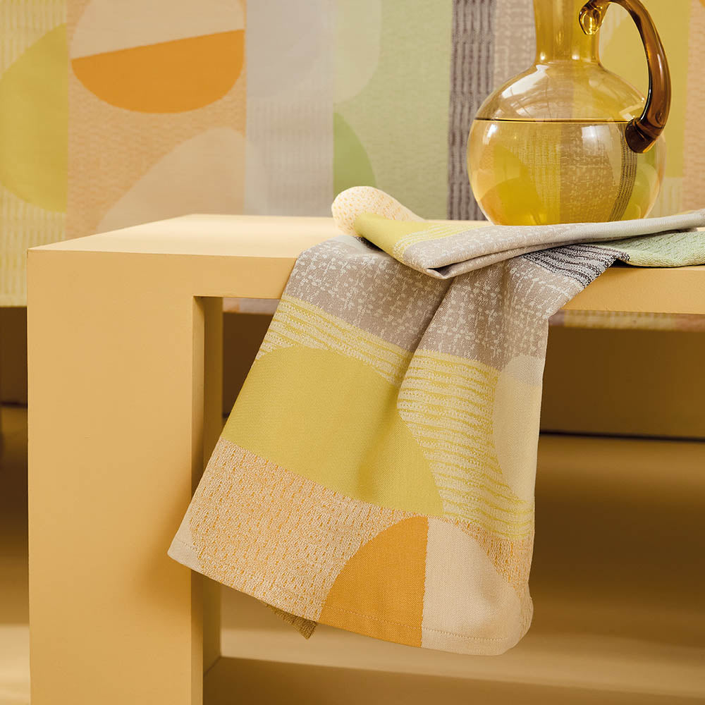 Mille Galets Terre Cuite Napkin, yellow, brown, and green circular pebble motif on cotton jacquard.