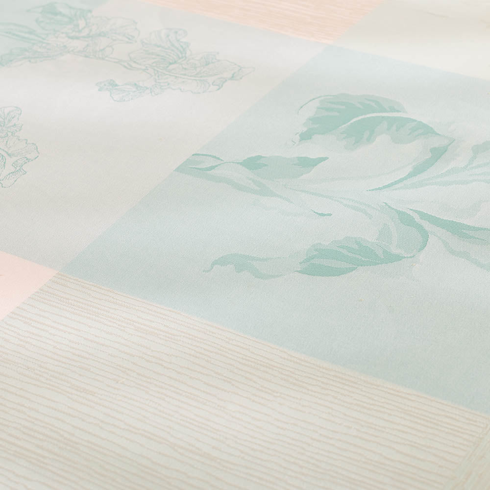 Close-up of the Mille Iris D'Eau Aqua Tablecloth featuring blue and white iris floral madras plaid on cotton jacquard.