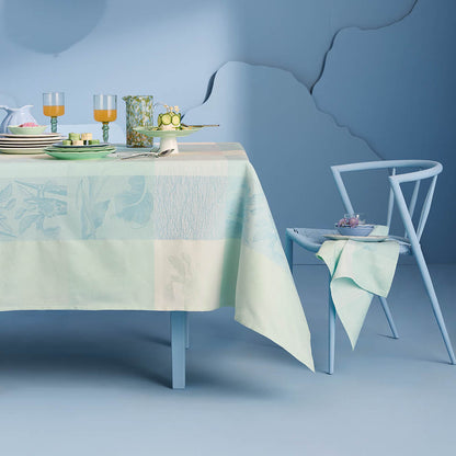 Mille Iris D'Eau Aqua Tablecloth, blue and white iris floral madras plaid on cotton jacquard set in a powder blue room.
