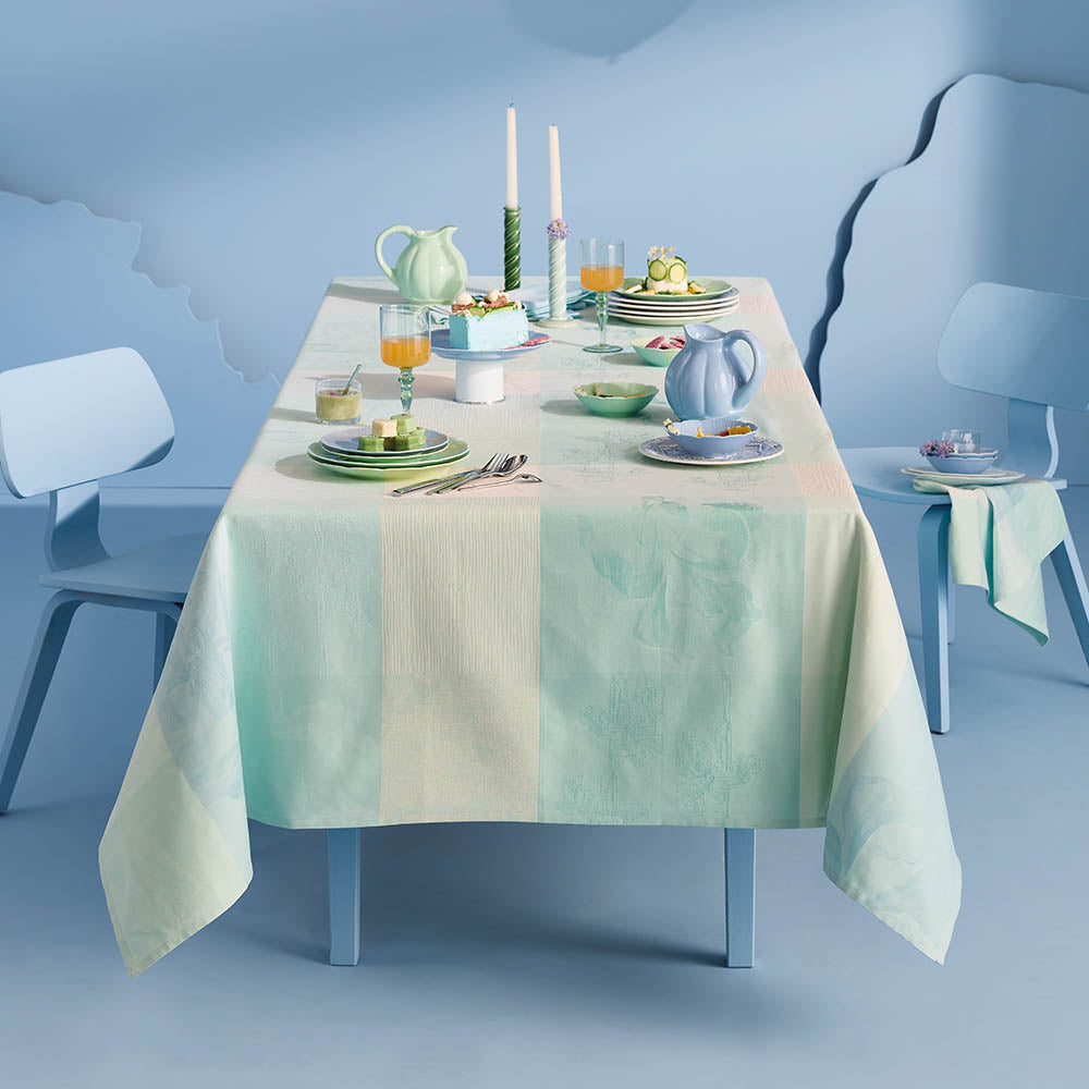 Mille Iris D'Eau Aqua Tablecloth, blue and white iris floral madras plaid on cotton jacquard, set for a pastel formal dining scene in a powder blue room.