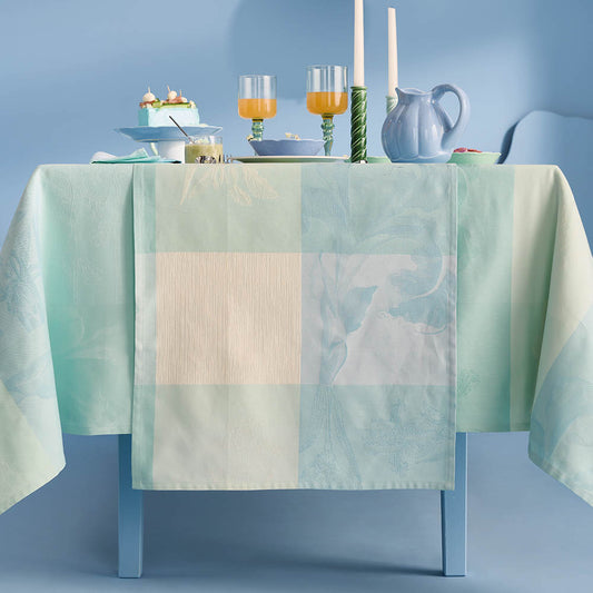 Mille Iris D'Eau Aqua Table Runner featuring blue, mint green, and cream iris floral madras plaid on cotton jacquard, set for a formal dining scene in a powder blue room.