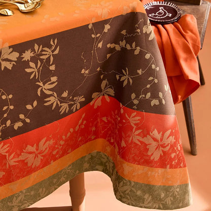 Close-up of intricately woven striped autumn leaf cotton jacquard tablecloth in orange, brown, and sage.