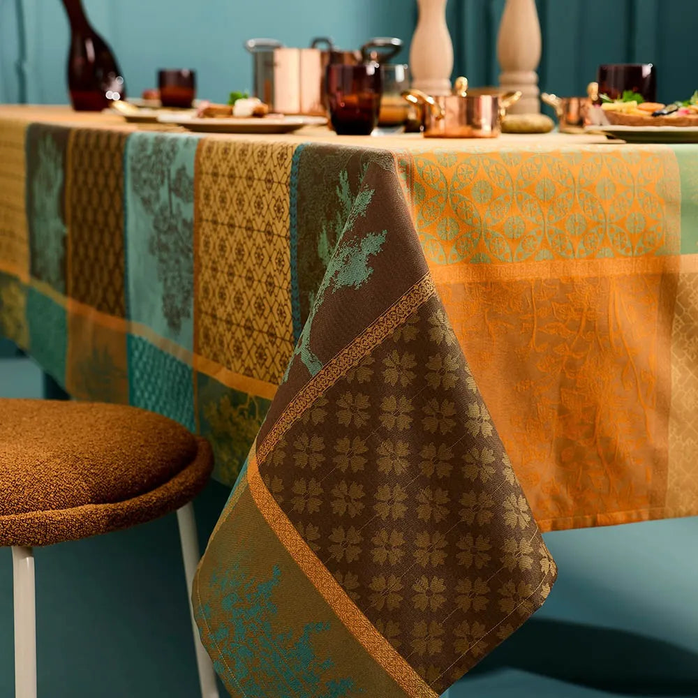 Geometric patchwork plaid tablecloth featuring woven tree patterns in warm autumn tones.