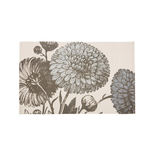 A top-down view of a rectangular cream cotton bath rug featuring a large-scale, detailed vintage botanical illustration of blossoming chrysanthemum flowers and buds in soft charcoal gray tones.