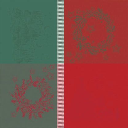 A flat lay of the Noel Magique Houx cotton jacquard napkin featuring a four-quadrant holiday design. The left half has a deep green background with a subtle woven wreath design on top and a red wreath design below. The right half features a vibrant red background with a gray wreath above, separated vertically by a woven white-and-red textured stripe.