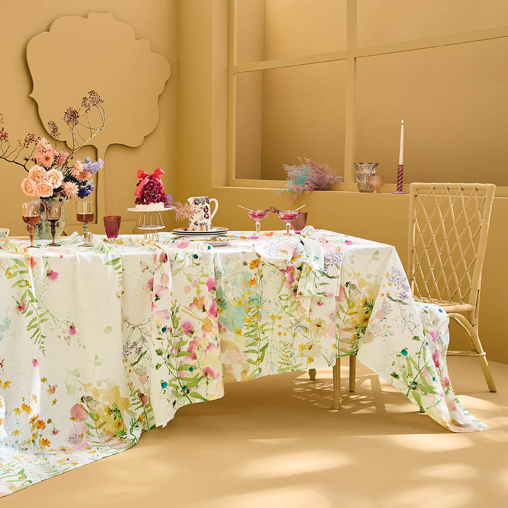Rosee Du Matin Printemps Tablecloth, pink and green watercolor floral print on cotton-linen blend, set for dining in a yellow room.