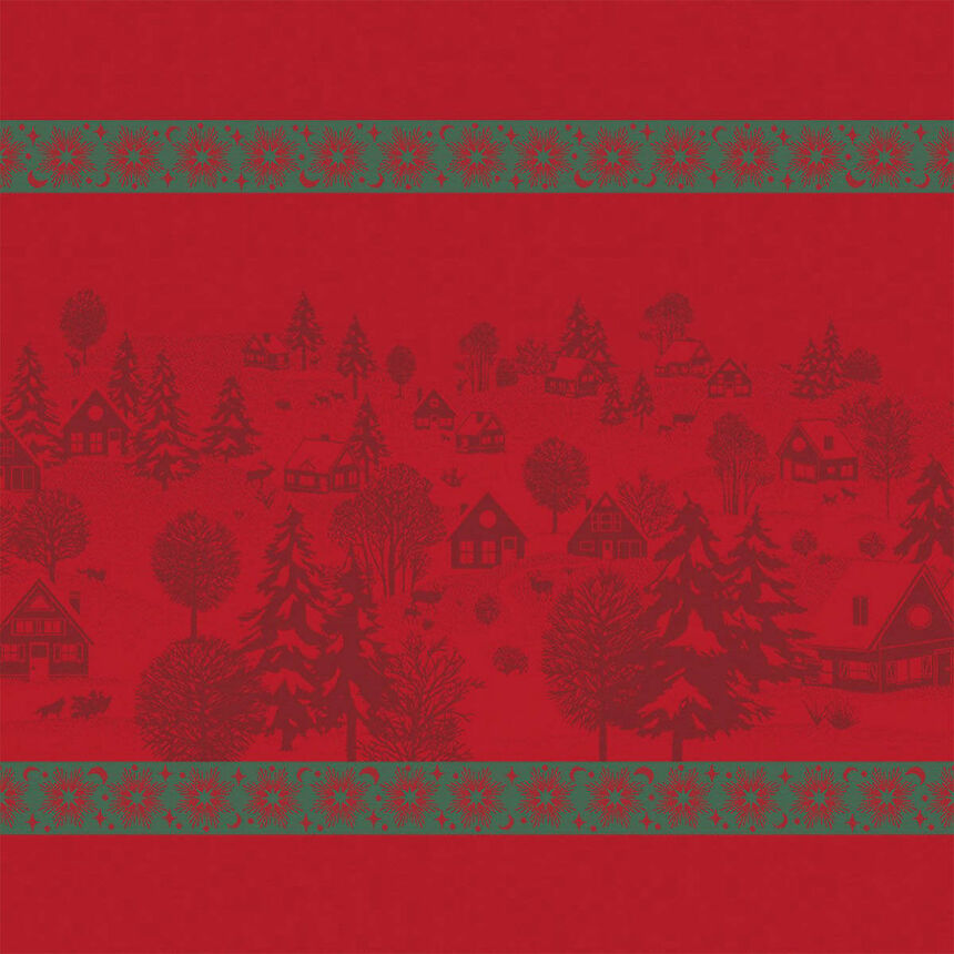 Full view of a red Sous Les Étoiles French cotton jacquard napkin featuring illustrations of a winter village and snowflakes in green trim.