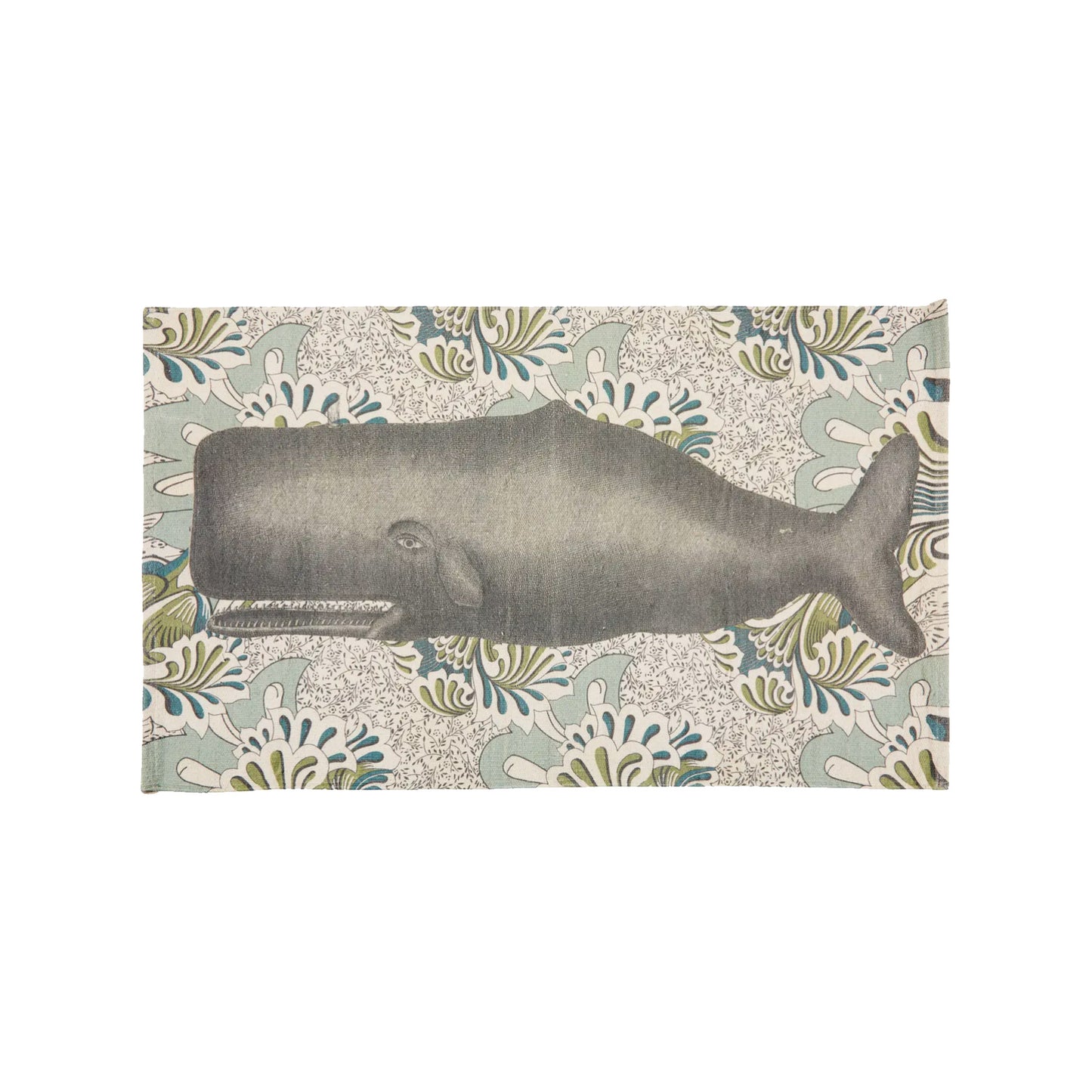 A top-down view of a rectangular, hand-loomed cream cotton bath rug featuring a large-scale illustration of a majestic charcoal gray whale set against an intricate, vintage botanical floral pattern background in soft sage green and denim blue tones.