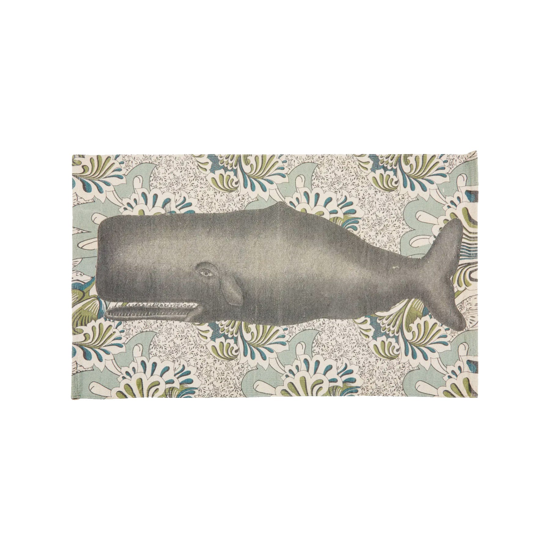 A top-down view of a rectangular, hand-loomed cream cotton bath rug featuring a large-scale illustration of a majestic charcoal gray whale set against an intricate, vintage botanical floral pattern background in soft sage green and denim blue tones.