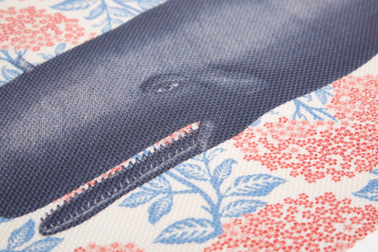 Close-up of a whale illustration with floral patterns on a vinyl placemat