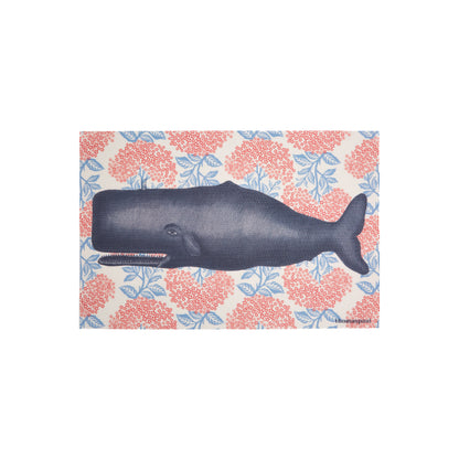 A whale illustration with floral patterns on a vinyl placemat